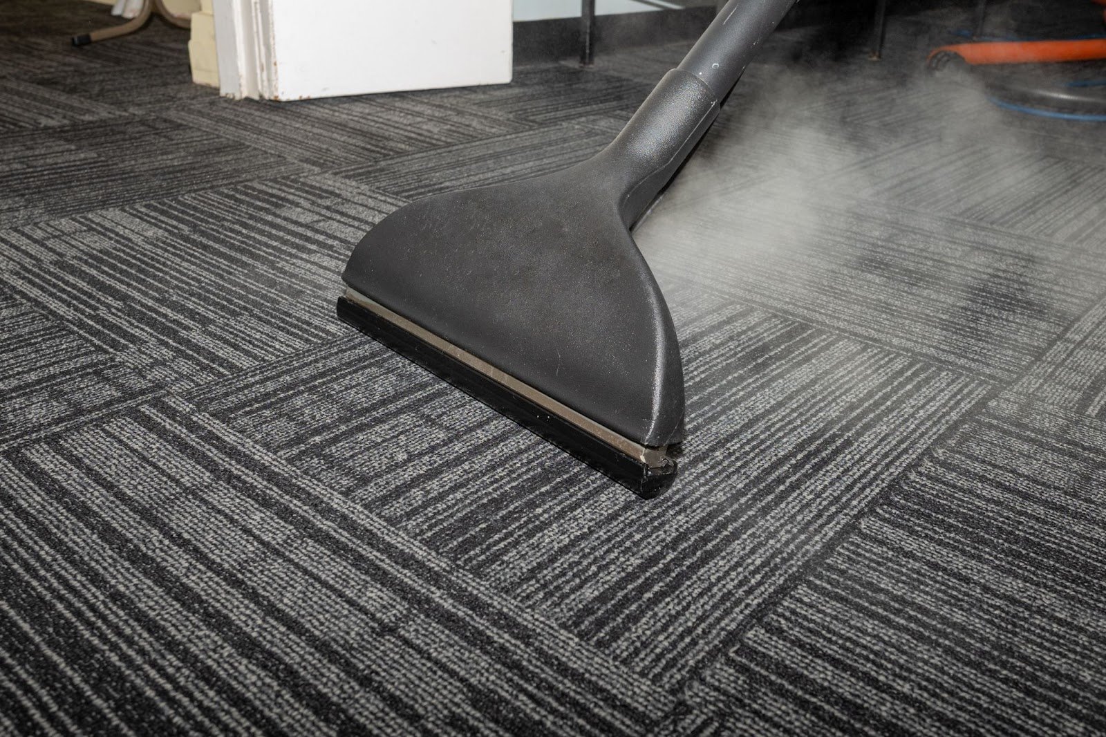 Steaming a gray carpet.