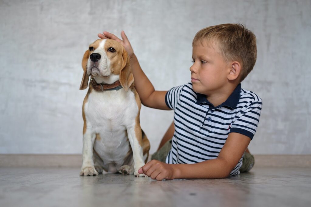 Kid and a dog on a hardwood floor.